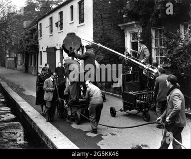 ALEC GUINNESS am Drehort offen mit Film Crew während der Dreharbeiten von VATER BROWN 1954 Regisseur ROBERT HAMER aus Geschichten von G.K. Chesterton Drehbuch Robert Hamer und Thelma Schnee Facet Productions / Columbia Pictures Corporation Stockfoto