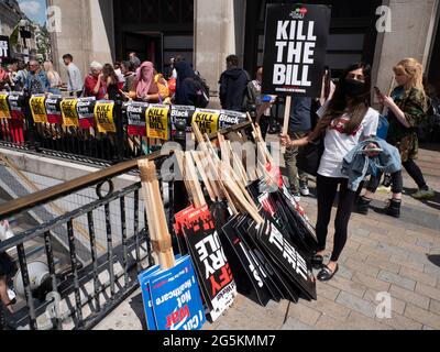 Londoner Proteste, Aktivisten protestieren in Zentral-London vor der Volksversammlung National Demonstration, junge Frauen halten das Plakat Kill the Bill vor einer Reihe von Plakaten am Oxford Circus Stockfoto