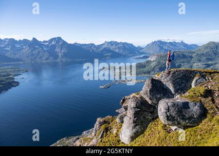 Junger Wanderer mit Blick auf Bergpanorama, Fjord Raftsund Berge, Blick von der Spitze des Dronningsvarden oder Stortinden, Vesterålen, Norwegen, Europa Stockfoto