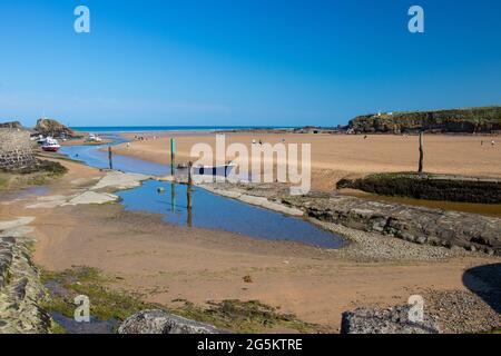 Blick auf das Meer über den sommerleaze Strand in Bude, Cornwall an einem sonnigen Tag im Sommer mit einem strahlend blauen Himmel. Stockfoto