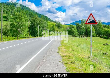 Ein Straßenschild, ein Symbol für Autofahrer, Warnung vor dem Aufstieg bergauf Stockfoto