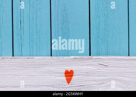 Orange Herz gemalt auf Distressed Vintage Boy Blue Grunge Holz Maserung Textur Hintergrund. Blau strukturierte Holzwand. Shabby Holz Stockfoto