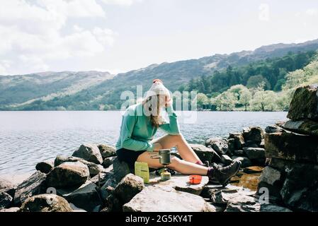 Frau, die sich während ihres Urlaubs in Wales, Großbritannien, in der Sonne entspannt Stockfoto
