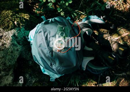 Kompass-Rucksack und Wanderschuhe auf dem Boden in freier Wildbahn Stockfoto