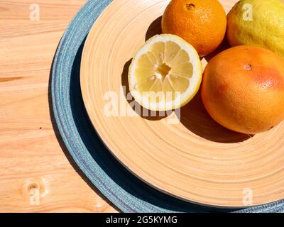 Mischen Sie Zitrusfrüchte in einer Holzschüssel auf dem Tisch Stockfoto