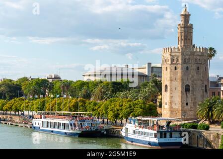 Blick über den Fluss Rio Guadalquivir auf der Promenade mit Ausflugsbooten und Torre del Oro, Sevilla, Andalusien, Spanien, Europa Stockfoto