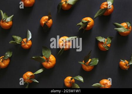 Draufsicht des Musters der Mandarinen auf dem schwarzen Hintergrund Stockfoto