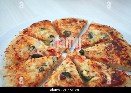 Pizzascheiben mit Tomaten, Käse und Basilikum Stockfoto