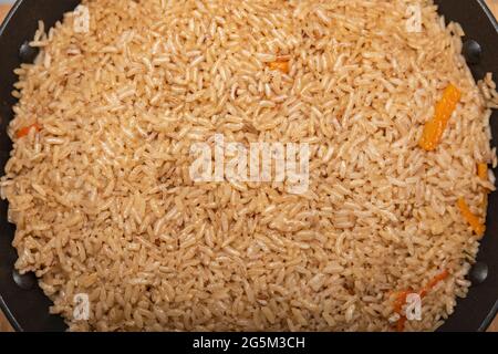 Pilaf Reis Nahaufnahme. Konzept der orientalischen Küche. Nationaler usbekischer Pilaf mit Fleisch in einer gusseisernen Pfanne. Draufsicht, Lamm, Devzira-Reis. Stockfoto