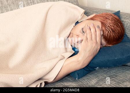 Eine junge Frau hat Kopfschmerzen. Migräne, Depressionen, schlechte Gesundheit Stockfoto