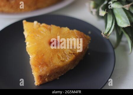 Scheibe karamellisierte Ananas auf dem Kopf. Auf der Oberseite befinden sich hausgemachte Ananaskuchen mit Ananasscheiben. Aufgenommen auf weißem Hintergrund Stockfoto