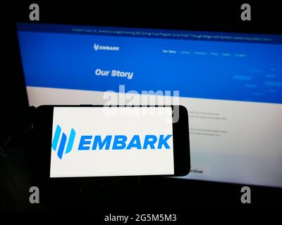 Person, die Mobiltelefon mit dem Logo des amerikanischen autonomen Fahrers Embark Trucks Inc. Auf dem Bildschirm vor der Webseite hält. Konzentrieren Sie sich auf die Telefonanzeige. Stockfoto