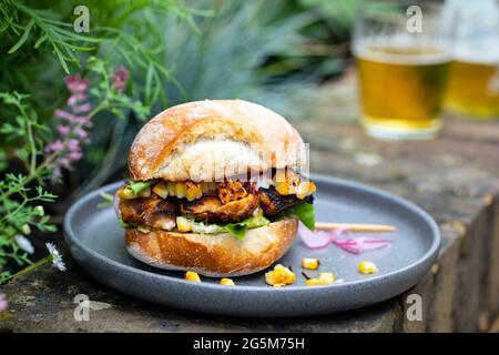 Rustikales Brötchen mit Chipotle-Huhn, gegrilltem Swet-Mais und Avocado Stockfoto