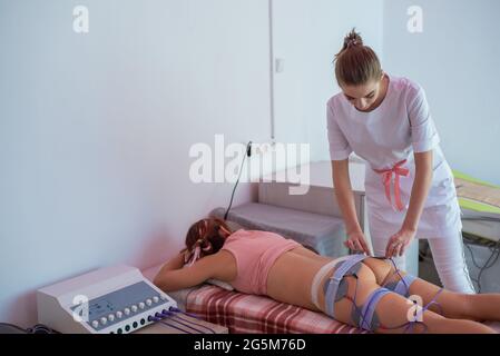 Miostimulation. Nicht-chirurgische Korrektur einer Figur in einem Schönheitssalon. Anti-Cellulite- und Anti-Fett-Hardware-Massage in der Klinik. Hardware Stockfoto