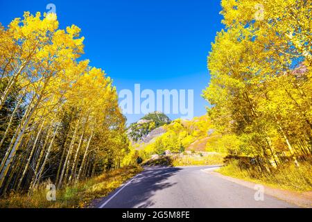 Blickpunkt Fahrt auf der Maroon Bells Creek Panoramastraße in Aspen, Colorado USA Rocky Mountains mit farbenfrohen Herbstlaub mit gelben Laubbäumen auf der Spitze Stockfoto