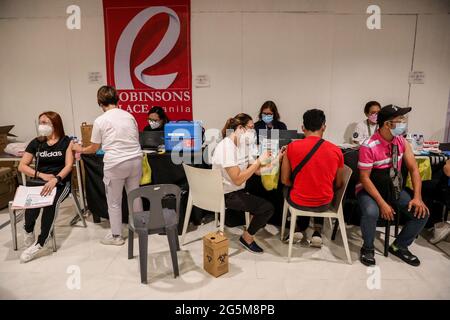 Gesundheitshelfer impfen Patienten mit dem Sinovac COVID-19-Impfstoff in einem Einkaufszentrum, das zu einer Impfstelle in Manila auf den Philippinen wurde. Stockfoto