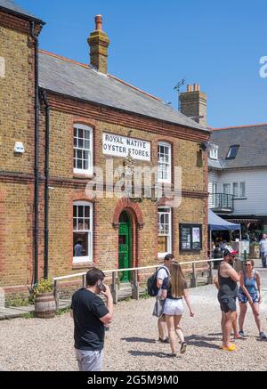 Gruppen von Menschen außerhalb des Royal Native Oyster Stores Seafood Restaurant an einem sonnigen Sommertag. Whitstable, Kent, England, Großbritannien Stockfoto