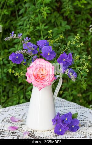 Bouquet von rosa Rose und lila Viola Blumen in Vintage Vase Stockfoto