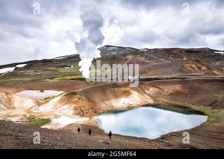 Menschen wandern auf dem Viti Krater von Krafla Caldera geothermische Formation mit kleinen See Wasser und Berge Schnee im Sommer und Geysir heißen Spri Stockfoto