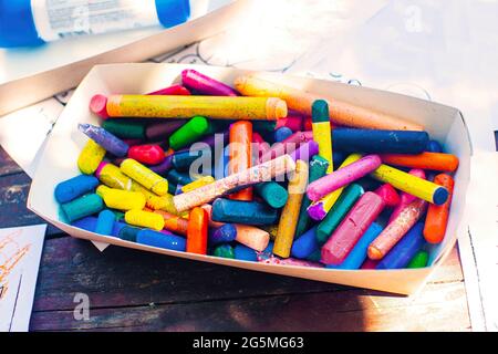 Eine Schachtel mit farbigen Wachsmalstiften auf dem Tisch, Buntstifte. Materialien für die Kreativität von Kindern. Stockfoto