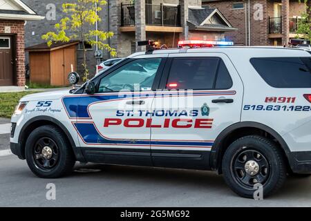 St. Thomas, Ontario, Kanada - 14 2021. Juni: St. Thomas Police Cruiser Fahrzeug geparkt auf Wohnstraße, blockiert die Straße, Lichter blinken oben. Stockfoto