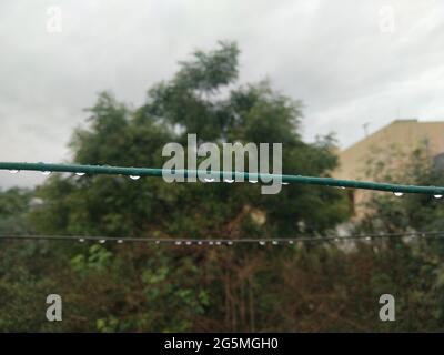 Regen fällt auf einen Stahldraht Stockfoto