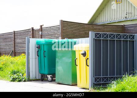 Plastikmüllbehälter auf der Straße in der Nähe des Hauses Stockfoto