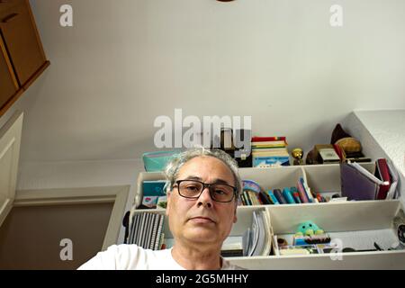 mature man in room placing things in a drawer seen from inside Stockfoto
