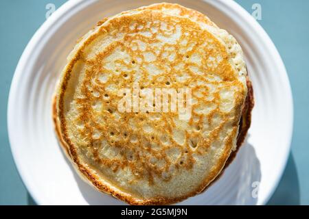 Makroaufnahme von oben, flache Ansicht von Stapel Buttermilch-Pfannkuchen auf dem Teller als traditionelles Frühstücksbrunch-Dessert Stockfoto