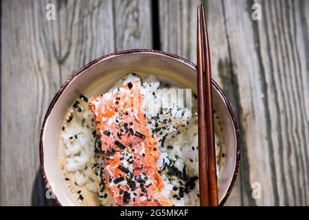 Nahaufnahme des traditionellen japanischen Grüntee-Gerichts in Asien namens Ochazuke mit gegrilltem Lachs, Reissesamesamen-Furikake und Nori in einer Schüssel mit Koteletts Stockfoto