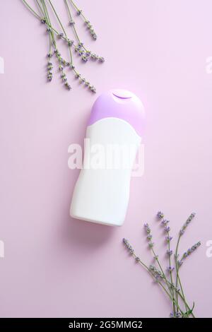 Natürliches Hautpflegeprodukt Flasche Mockup mit Lavendel auf violettem Hintergrund. Flach liegend, Draufsicht. Kräuterbeautheit Produkt Container Design. Stockfoto