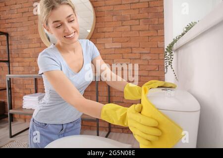 Junge Frau putzte toilette im Bad Stockfoto