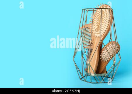 Kerzenhalter mit Haarbürsten und Kämmen auf farbigem Hintergrund Stockfoto