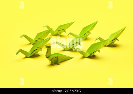 Origami-Dinosaurier auf farbigem Hintergrund. Konzept der Einzigartigkeit Stockfoto