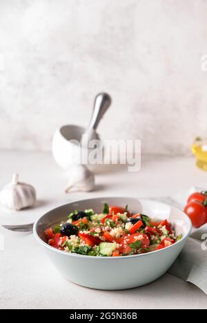 Schüssel mit Couscous und Gemüse auf hellem Hintergrund Stockfoto