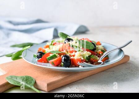 Teller mit Couscous und Gemüse auf hellem Hintergrund, Nahaufnahme Stockfoto