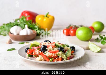 Teller mit Couscous und Gemüse auf hellem Hintergrund Stockfoto
