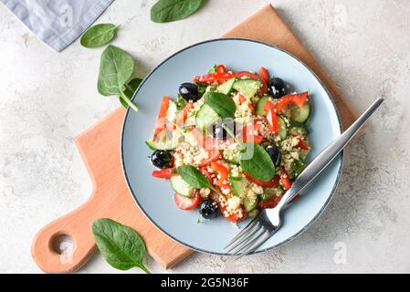 Teller mit Couscous und Gemüse auf hellem Hintergrund Stockfoto
