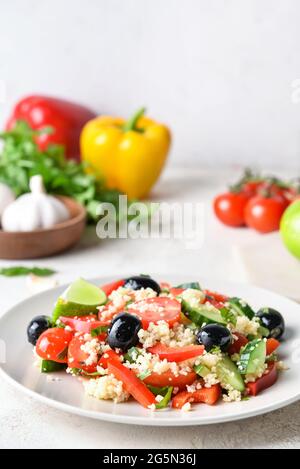 Teller mit Couscous und Gemüse auf hellem Hintergrund Stockfoto