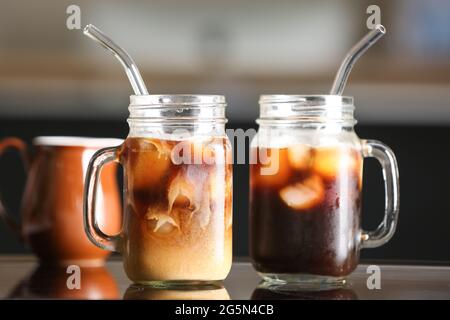 Mason Gläser mit leckerem Eiskaffee auf dem Tisch Stockfoto