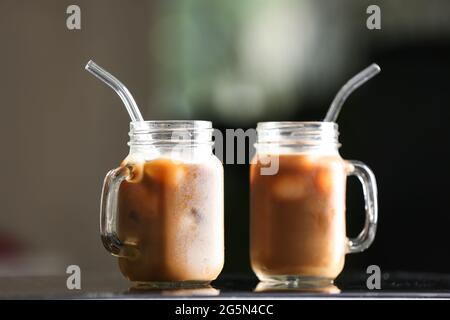 Mason Gläser mit leckerem Eiskaffee auf dem Tisch Stockfoto