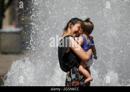 Portland, USA. Juni 2021. Der Salmon Springs Fountain ist sehr beliebt, da die Menschen in Portland, Oregon, am 28. Juni 2021 Rekordtemperaturen von bis zu 116 Grad erdulden (Foto: John Rudoff/Sipa USA) Quelle: SIPA USA/Alamy Live News Stockfoto