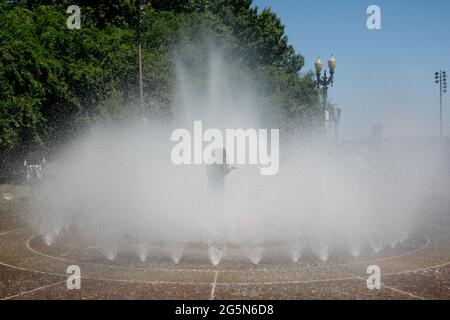 Portland, USA. Juni 2021. Der Salmon Springs Fountain ist sehr beliebt, da die Menschen in Portland, Oregon, am 28. Juni 2021 Rekordtemperaturen von bis zu 116 Grad erdulden (Foto: John Rudoff/Sipa USA) Quelle: SIPA USA/Alamy Live News Stockfoto