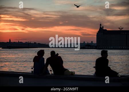 Istanbul, Türkei. Juni 2021. Die Leute sitzen am Strand, um die wunderschöne Aussicht auf den Sonnenuntergang an Istanbuls Kadikoy-Küste zu genießen. Kredit: SOPA Images Limited/Alamy Live Nachrichten Stockfoto