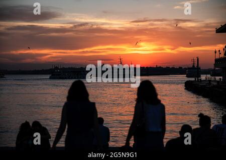 Istanbul, Türkei. Juni 2021. Die Leute sitzen am Strand, um die wunderschöne Aussicht auf den Sonnenuntergang an Istanbuls Kadikoy-Küste zu genießen. Kredit: SOPA Images Limited/Alamy Live Nachrichten Stockfoto