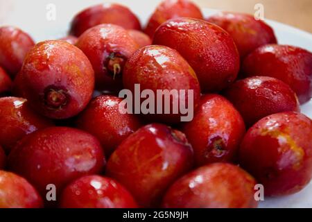 Rote Datteln isoliert auf einer Keramikplatte Stockfoto