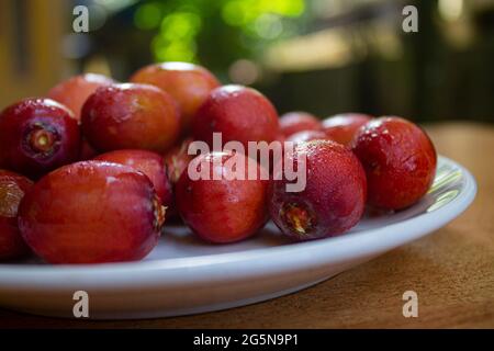 Rote Datteln isoliert auf einer Keramikplatte Stockfoto