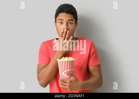 Afroamerikanischer Teenager, der sich auf hellem Hintergrund einen Film ansieht Stockfoto