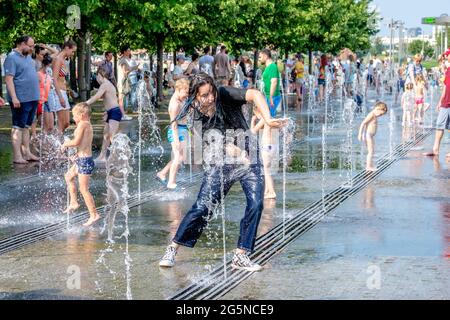 Moskau, Russland, 26. Juni 2021. Frauen, Männer und Kinder baden in den Jets des Brunnens im Muzeon Park. Wasserunterhaltung für die Stadtbewohner Stockfoto