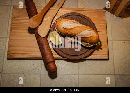 Milanesa argentinisches Steak-Sandwich mit Salat, Tomaten, Käse, Ei, Zitrone, Würstchen, Pommes. LKW-Lebensmittel. Fast Food. Selektiver Fokus. Stockfoto